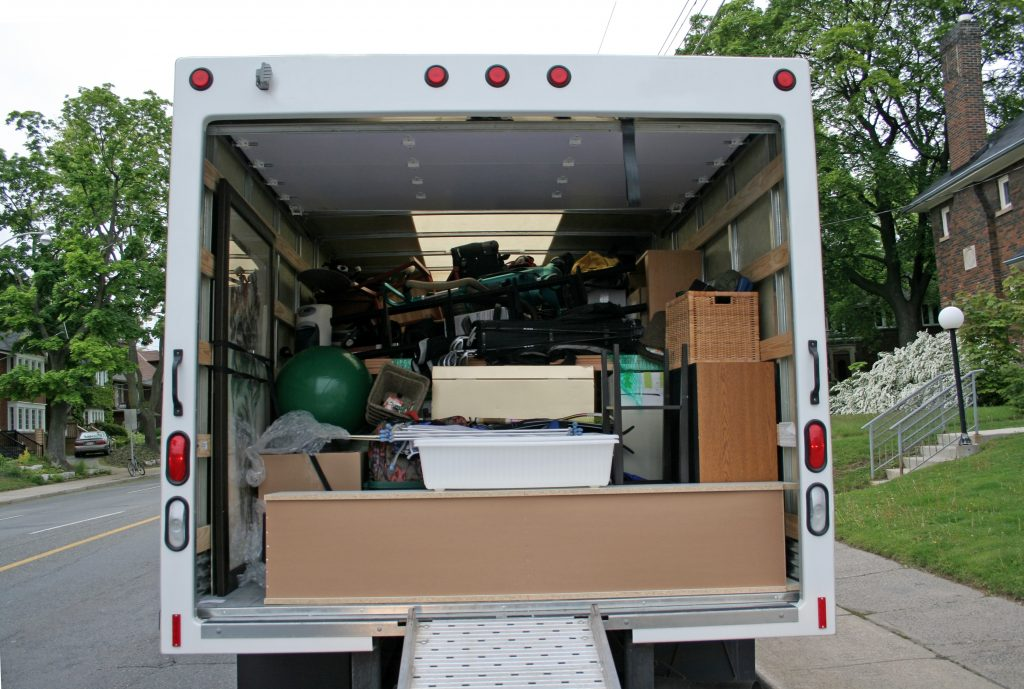 Two guys carrying a sofa into a truck